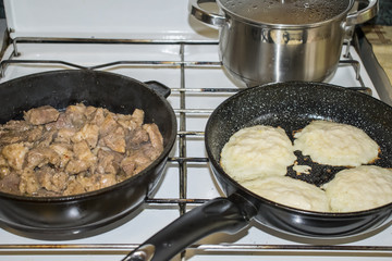 Traditional Russian pancake pancake on a cast-iron frying pan