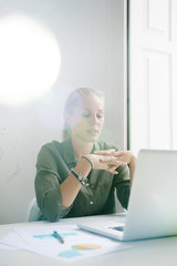 Seated woman holds her hands in front of her