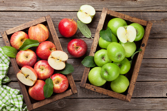 Green and red apples in wooden box