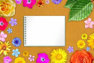 Beautiful flower frame with copybook in center on orange gentle leather background. Floral composition of spring or summer flowers.