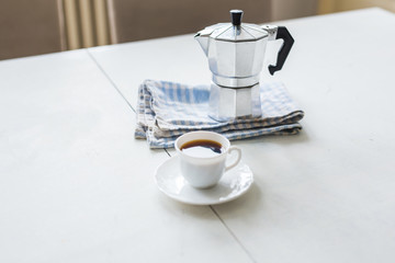 Vintage coffee pot, a cup of coffee is on a white table