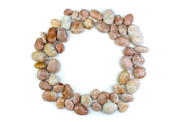 Round frame of small sea stones, isolated on white. Top view with copy space.