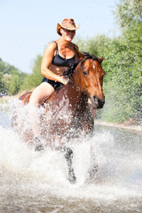 Happy woman galloping in the water