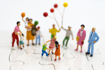 Fototapeta premium Miniature family: Childrens playing balloon together. Image use for background International day of families concept.