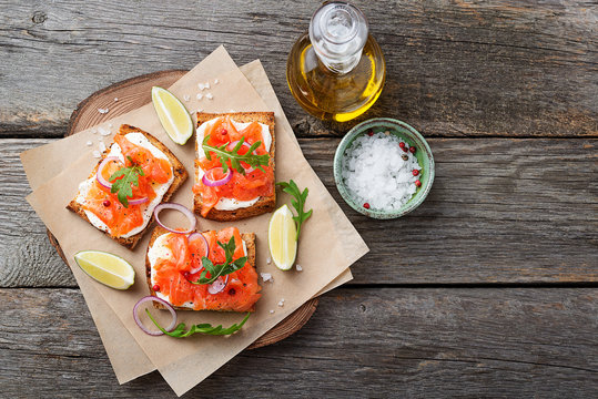 Smoked Salmon Sandwich With Cream Cheese On Wooden Table. Top View