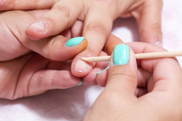 Obraz na płótnie Canvas Woman in salon receiving manicure by nail beautician