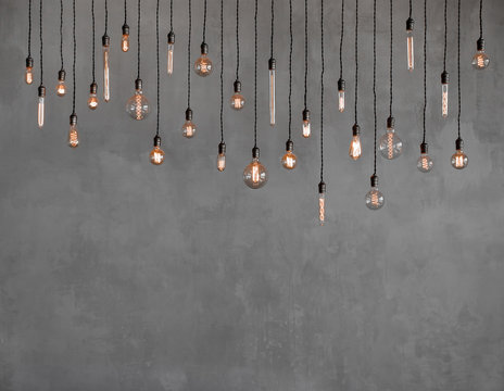 Edison retro lamp Incandescent bulbs on gray plaster wall background in loft. Concept Vintage style. Copy space