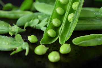 Green pea pods against the dark background