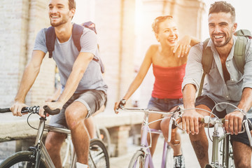 Happy friends riding bicycles in city center