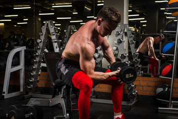 the sportsman is engaged in an exercise room, pumps muscles, a biceps and a press