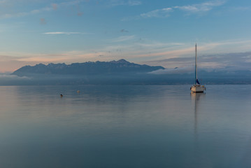Obraz na płótnie Canvas Colorful sunrise on the marina of Lausanne on the Lake Leman in summer with the view of the Swiss Alps in background - 24
