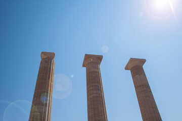 Columns on the hellenistic stoa of the Acropolis of Lindos, Rhodes, Greece, Blue sky, olive tree...