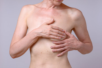 Woman is examining her breast