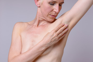Woman is examining her breast