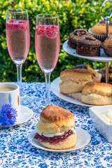 Afternoon tea with cakes and traditional English scones with strawberry jam and clotted cream set...