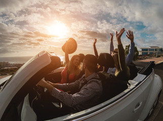 Happy people having fun together in convertible car in summer vacation