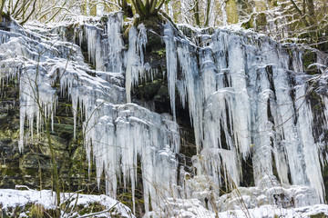 Fototapeta na wymiar Icicles on the rocks inside of the forest