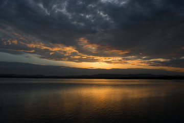 Naklejka na ściany i meble Beautiful sunset on the lake with the reflection of clouds