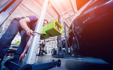 Worker checks and adjusts the headlights of a car's lighting system