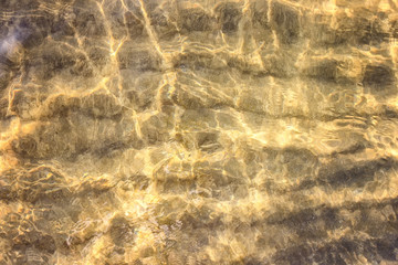 The background of sand on the seabed through a layer of clear and transparent sea water
