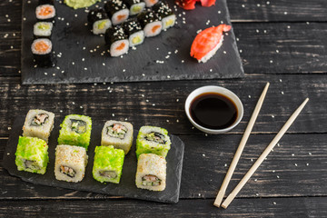 Fresh and tasty sushi on dark background. It can be used as a background