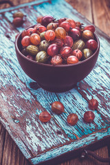 old wooden tray with gooseberry on the table