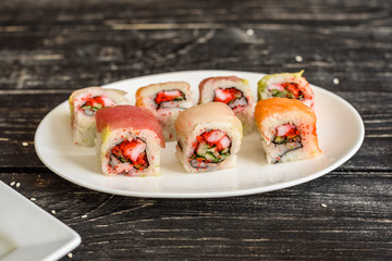 Fresh and tasty sushi on dark background. It can be used as a background