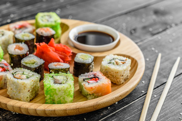 Fresh and tasty sushi on dark background. It can be used as a background