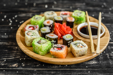 Fresh and tasty sushi on dark background. It can be used as a background