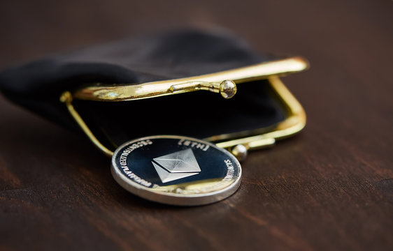 crypto coin in wallet on wooden surface