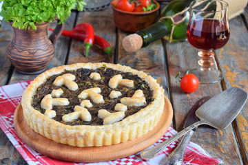 Homemade pie with mushrooms and herbs. Quiche on wooden background. Vegetarian food.
