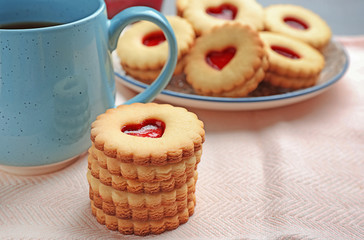 Traditional Christmas Linzer cookies with sweet jam on table