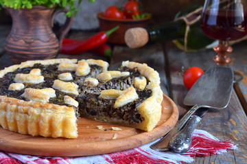 Homemade pie with mushrooms and herbs. Quiche on wooden background. Vegetarian food.