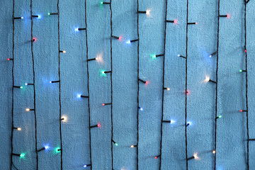 Beautiful bright Christmas lights on color background