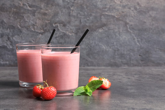 Glasses with tasty strawberry smoothie on table