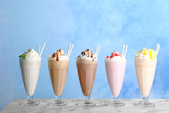 Glasses with delicious milk shakes on table