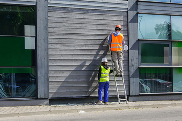 Fototapeta premium two workers paint the wall