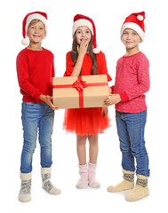 Cute little children in Santa hats with Christmas gift box on white background