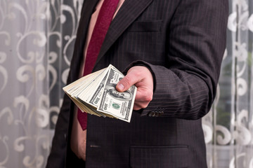 Man showing his profit in dollar banknotes