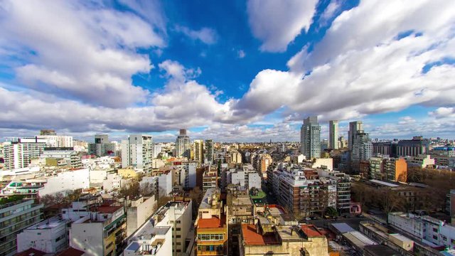 Time-lapse view on the skyline of the city from a balcony of a high rise apartment as Sun breaks through between fast move clouds in Buenos Aires.
