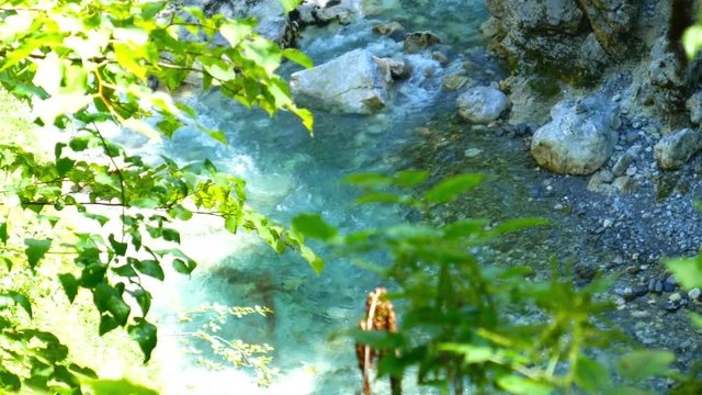 View on the distinct emerald green Soca River as it flows through the rocky riverbed in Slovenia.
