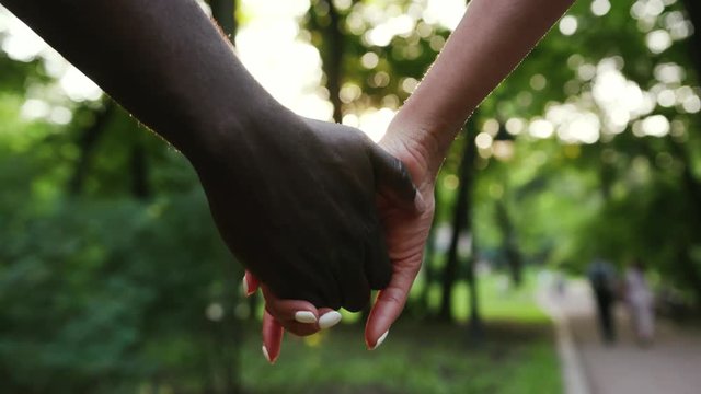 Slow motion close up African American couple holding hands and walking in park woman sunny love summer man nature black outdoors together happiness two romance friendship dating friends relationship