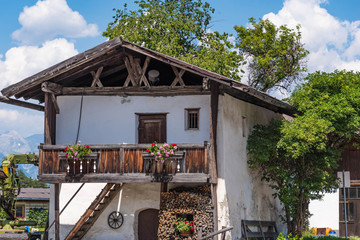 Altes Haus mit Holzbalkon und Blumen