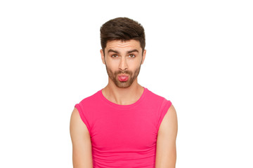Funny emotional sexy male model in a pink t-shirt on white background