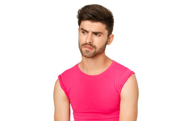 Funny emotional sexy male model in a pink t-shirt on white background