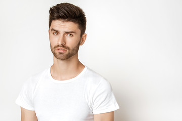 Fototapeta premium Strong face male model in casual style in white t sirt and jeans on white background
