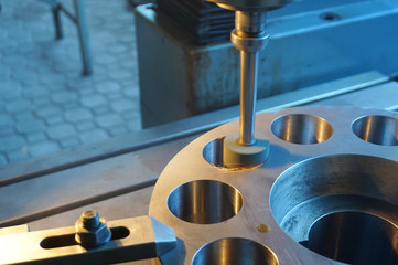 Machining of the internal hole on a coordinate grinding machine with sparks, in an industrial plant.