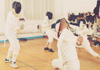 Fototapeta premium Mixed age group of athletes at fencing workout