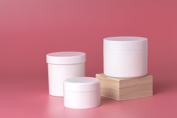 Round packaging of cream. Jar of cream isolated on pink background