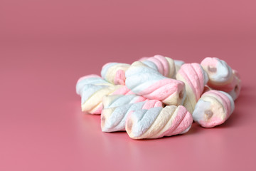 Fototapeta na wymiar Twisted american marshmallow on pink background